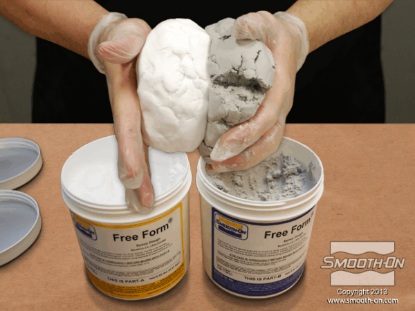 Hands mixing two types of clay